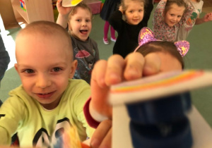 Patryk prezentuje swoje kastaniety, w tle widać Gabi, Ninkę i Alę S.