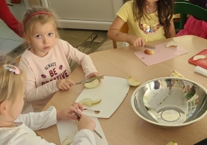 Zosia, Marta, Elenka podczas krojenia jabłek przy stoliku