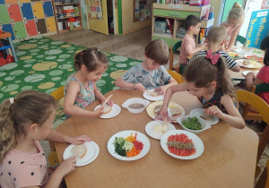Dzieci kroją warzywa.