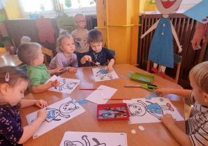 Dzieci pracuja przy stolikach
