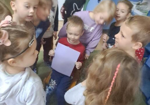 Dzieci ustawiły się przy koledze z kartką w kolorze fioletowym