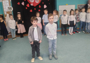 Miłosz i Marcel stoją na środku sali, recytują wiersze dla Babci i Dziadka