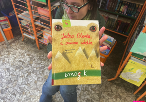 Pani Zdzisia pokazuje dzieciom książkę pt" Jedna literka a zmiana wielka".