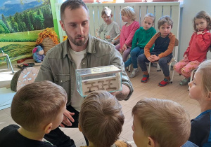 Dzieci przyglądają się robotnicy i królowej mrówek
