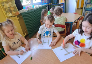 Oliwka, Jaś, Hania kreślą litery "H" na kartach w rytmie piosenki "Halina"