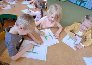 Stasio, Gabrysia, Lena kreślą litery "H" na kartach w rytmie piosenki "Halina"