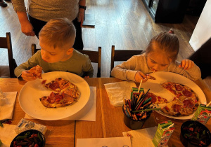 dzieci jedzą pizze