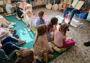 Dzieci oglądają obrazki ilustrujące opowieść "O Wilku, który wypadł z książki"
