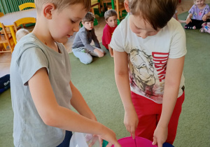 Chłopcy dodają startą skórkę cytryny do miski z ciastem