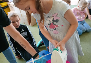 Dziewczynka miksuje ciasto za pomocą miksera