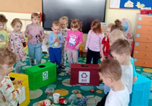 Dzieci szukają odpadów na dywanie.