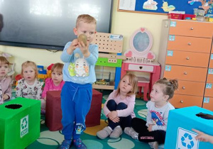 Olek wrzuca odpa do brązowego pojemnika.
