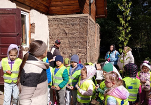Dzieci oglądają wiejską zabudowę pokrytą słomą