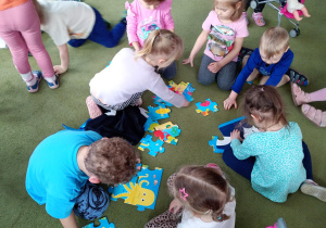 Puchatki składają wspólnie puzzle przedstawiające wodny świat