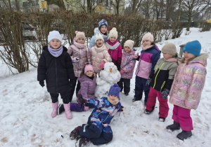 Dziewczynki z delfinków pozują ze swoim bałwanem