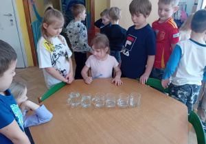 Zuzia G. gra na szklankach wypełnionych wodą
