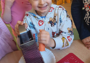 Dzieci z zaangażowaniem przygotowywały składniki do ciasta- samodzielnie tarły marchewkę na tarce