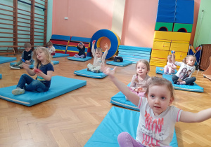 Dzieci przekładają woreczki z ręki do ręki nad głowami