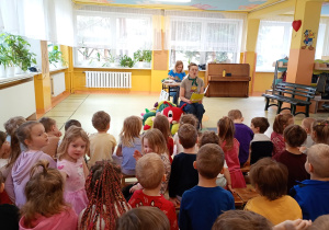 Prowadząca czyta fragment książki dzieciom