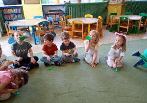 Maluszki próbują za pomocą wdechu podnieść liście na słomkach