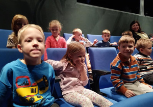 Dzieci siedzą w sali teatralnej