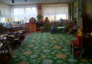 Sala grupy Misie jest urządzona w kolorystyce zieloenj i żółtej. Z lewej strony stoją stoliki dziecięce, na końcu sali znajdują się kolorowe regały z zabawkami.