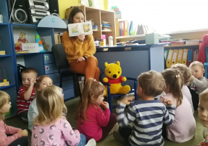 Dzieci słuchają książki o urodzinach Puchatka