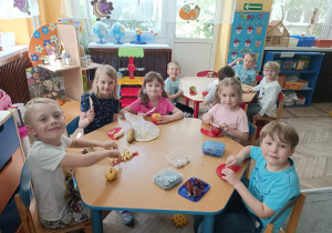 Dzieci ze stolika niebieskiego kroją owoce do miski
