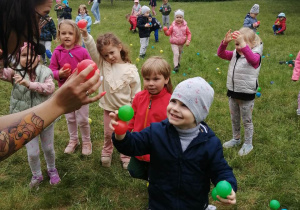 Dzieci odnajdują kolorowe piłeczki.