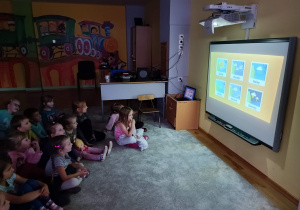 Grupa ogląda film edukacyjny na tablicy interaktywnej