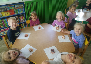 Dzieci przy żółytym stoliczku z ciastem śliwkowym