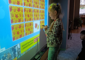 Dziewczynka zaznacza odpowiedź na tablicy interaktywnej