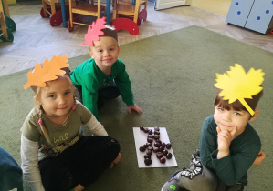 Klara, Antoś i Tymek ukłożyli drzewo z darów jesieni