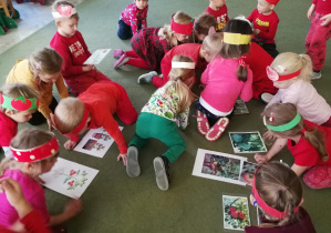 Dzieci oglądają obrazki różnych pomidorów i jego etapów wzrostu
