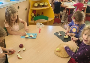 Alicha, Gabi, Emilka, Justyna podczas krojenia jabłek przy stoliku