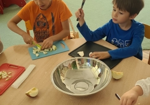 Jaś i Sasza podczas krojenia jabłek przy stoliku