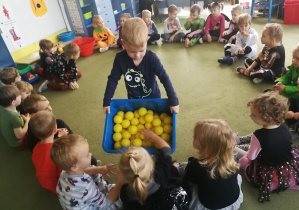 Filip rozdaje przedszkolakom żółte piłeczki