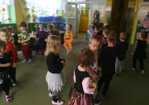 Dzieci poruszają się po sali z żółtymi piłeczkami