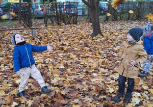 Tymek i Antoś bawią się wśród jesiennych liści