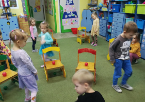 Dzieci układają piłeczki w odpowiednim układzie na krzesłach