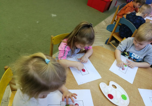 Gabrysia, Filip i Marysia tworzą kropki z farby na kartach z sygnalizatorami, rytmizując piosenkę "Kolorowe światła"