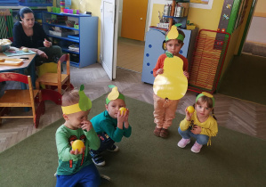 Tymek, Lena i Kuba, trzymający żółte piłeczki-gruszki, usiedli przy Gruszy - Olafie