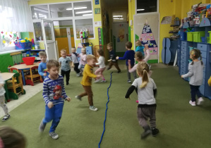 Dzieci poruszają się po sali w rytmie gry na tamburynie