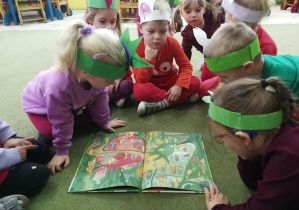 Dzieci oglądają przekrój buraka w książce "Przekroje owoców i warzyw"