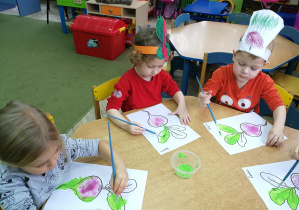 Remik, Laura i Filip malują farbą liście buraków
