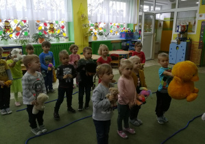 Dzieci słuchają piosenki "Miś jest tu" i obserwują do niej ruch taneczny