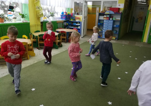 Dzieci poruszają się po sali podczas zabawy "Dzielimy się opłatkiem"