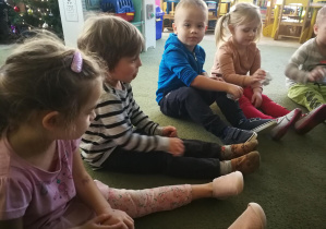 Dzieci masują swoje prawe nogi za pomocą kulek z kartek - śnieżek