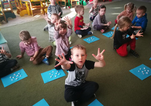 Dzieci wskazują na palcach ile kropek policzyły na wzorze