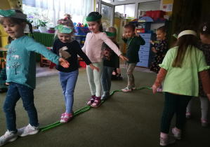 Dziewczynki idą po linie ułożonej w kształcie ogórka do piosenki "Ogórek Wąsaty"